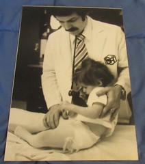 1977 Sandy Underwood photograph; Doctor examining child #3, 9 1/2″ x 14″